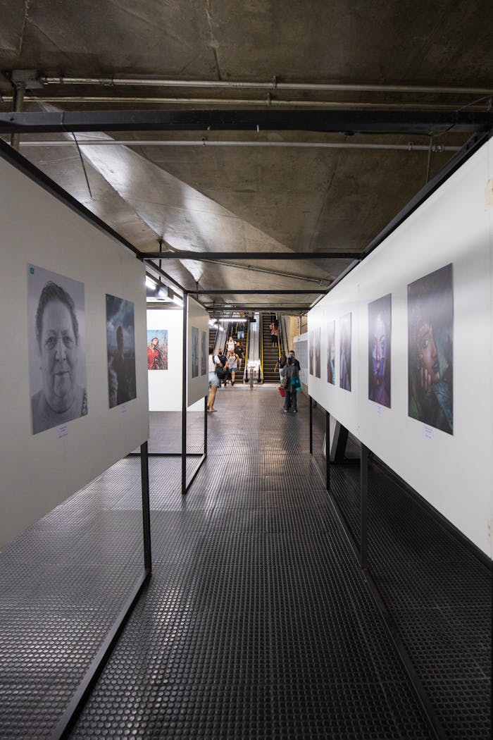 Explore a contemporary art gallery corridor featuring diverse photo exhibits and visitors.