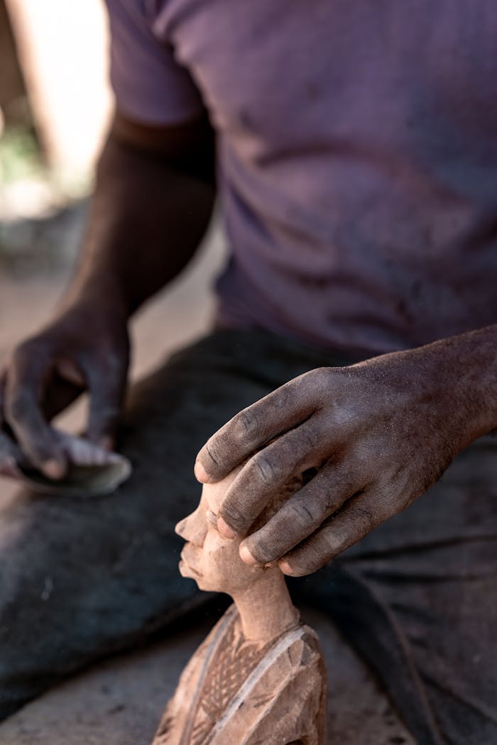 Close up of an artisan crafting a wooden sculpture in Nigeria, showcasing skilled craftsmanship.