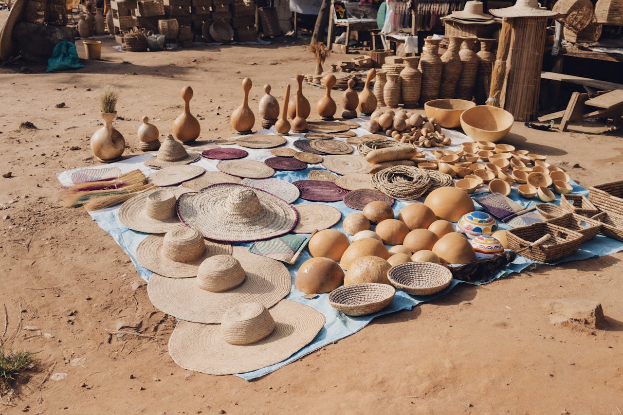 A vibrant display of handcrafted hats and baskets at a local market in Abuja, Nigeria.