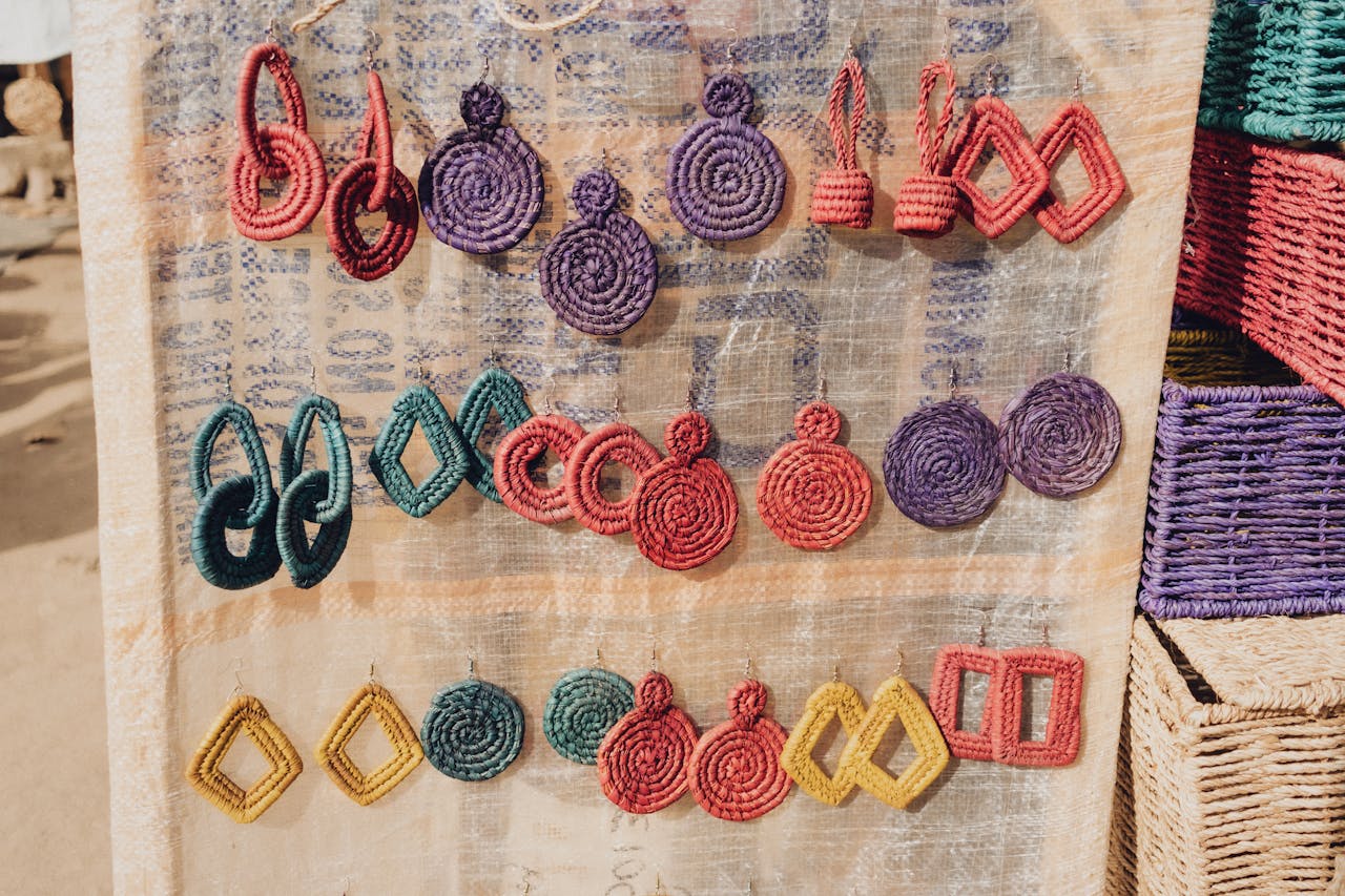 who-we-are-01 Vivid handcrafted earrings displayed at a market in Abuja, showcasing African art and craftsmanship.